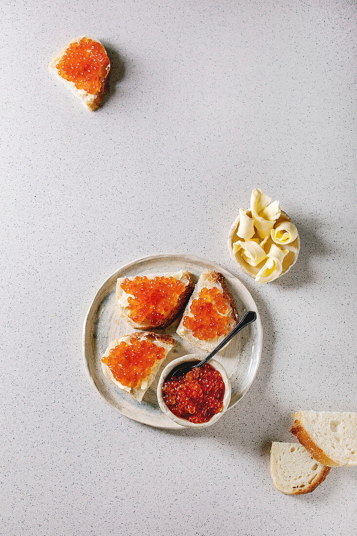 Red salmon caviar in bowl and on wheat bread, served with butter