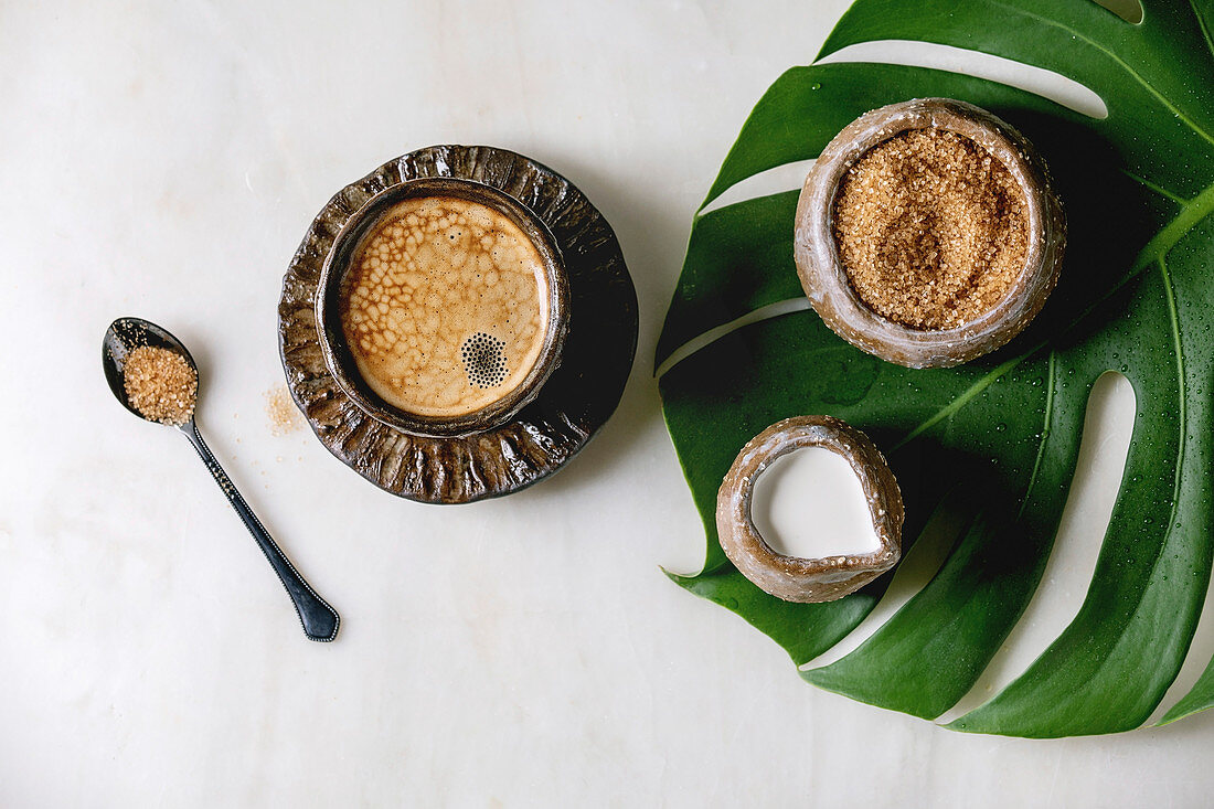 Espresso in Keramiktasse serviert dazu brauner Rohrzucker und Sahne