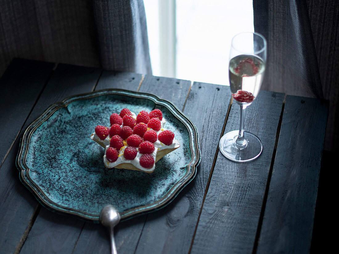 A star shaped ricotta cake with raspberries and a glass of champage