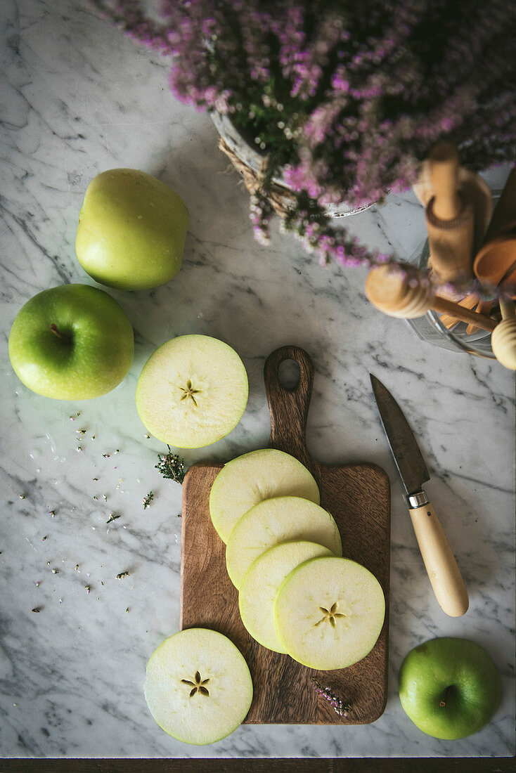 Fresh ripe green apple, sliced oon a work surface in a kitchen