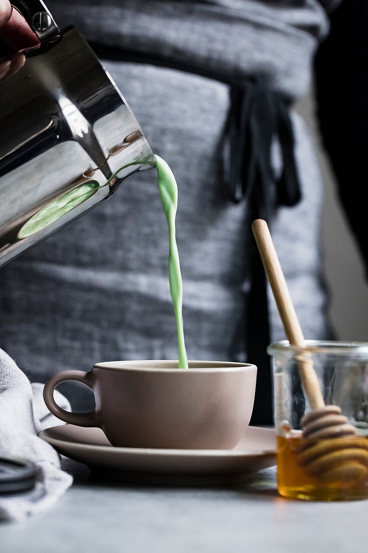 Matcha latte being poured into a cup