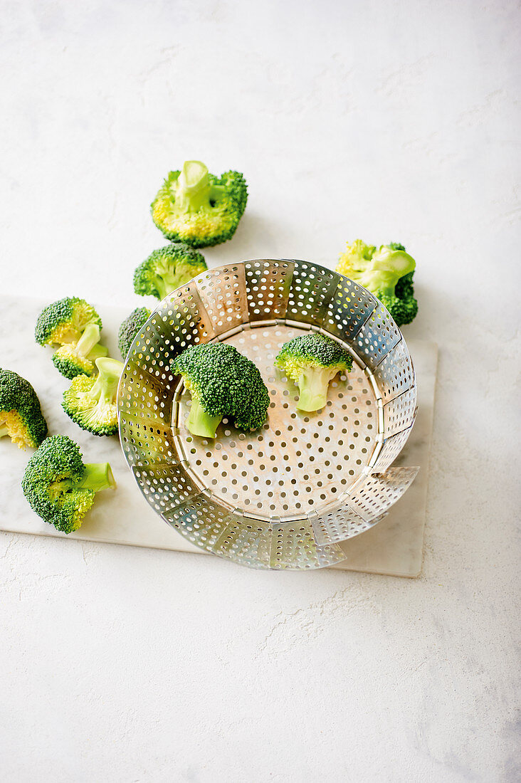 Broccoli florets in a steamer insert
