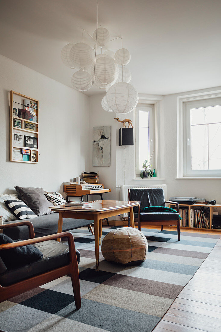 Retro armchairs in living room in shades of grey with vintage-style accessories