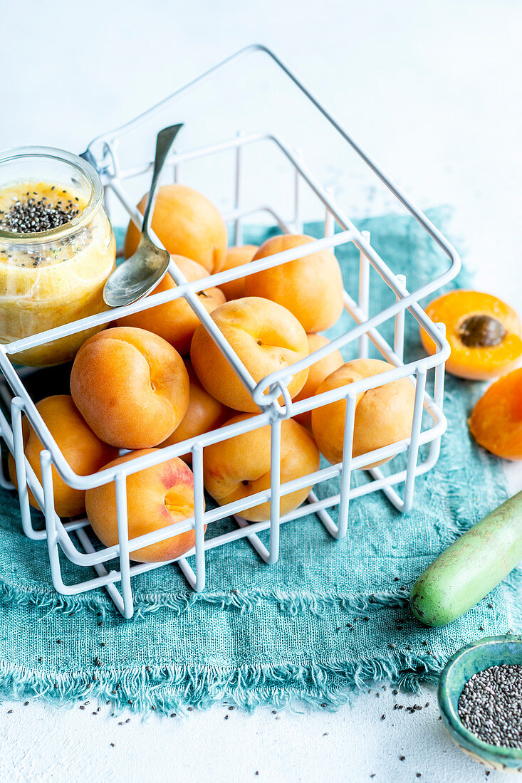 Aprikosendessert mit Chiasamen und frischen Aprikosen in Metallkörbchen