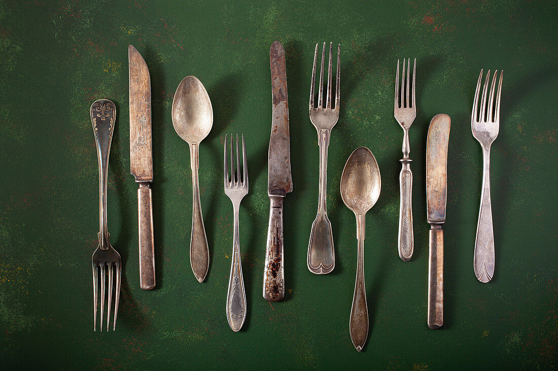 Vintage cutlery on a green surface
