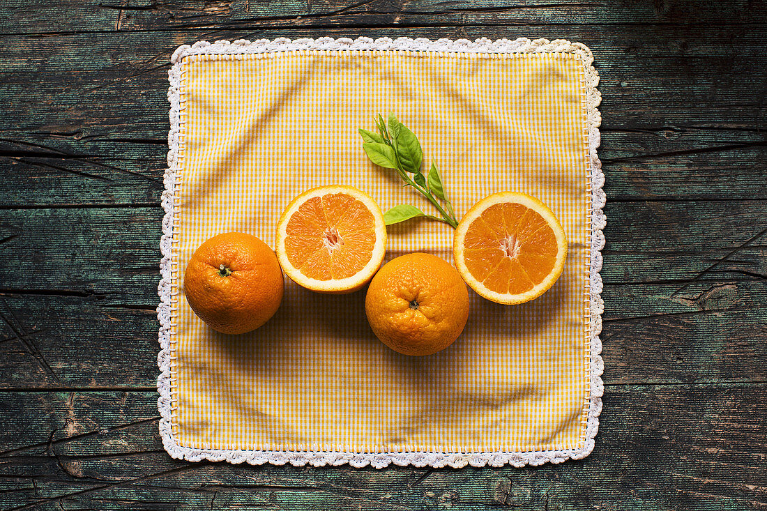 Halves of fresh oranges on a wooden dark rustic table on a dark background