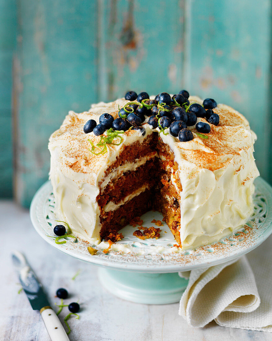 Layered carrot cake with buttercream icing and blueberries