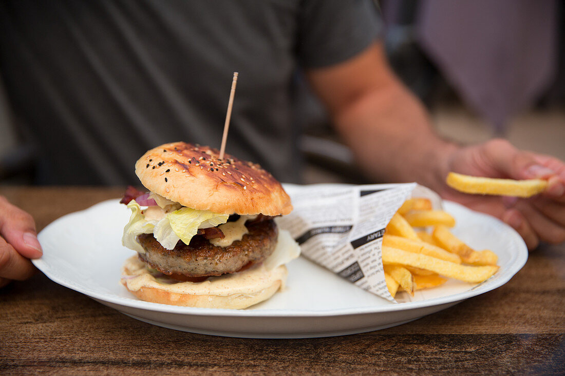 A burger with chips in newspaper