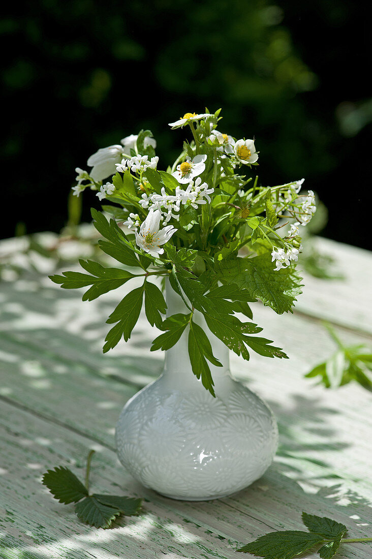 Posy of wild strawberry and sweet woodruff flowers in vase