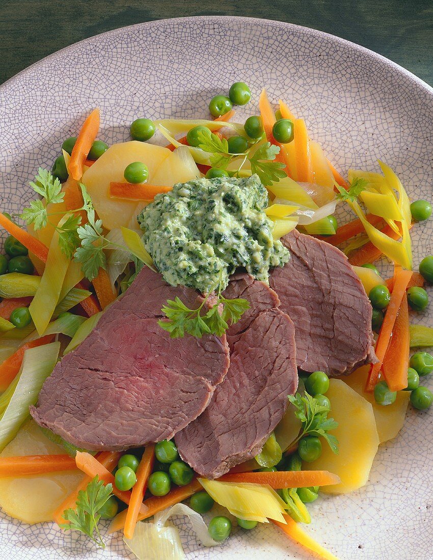 Three boiled beef slices with herb mousse on vegetables
