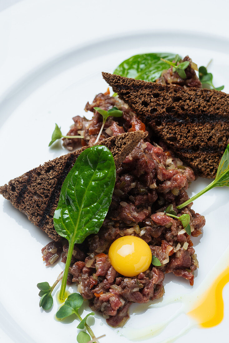 Tartar with dark bread toasts and exquisite and yolk