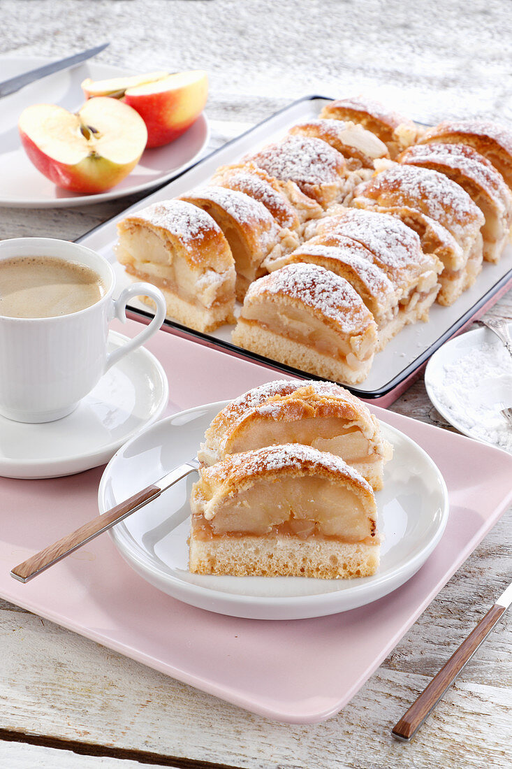 Apfelkuchen mit Puderzucker, in Stücke geschnitten