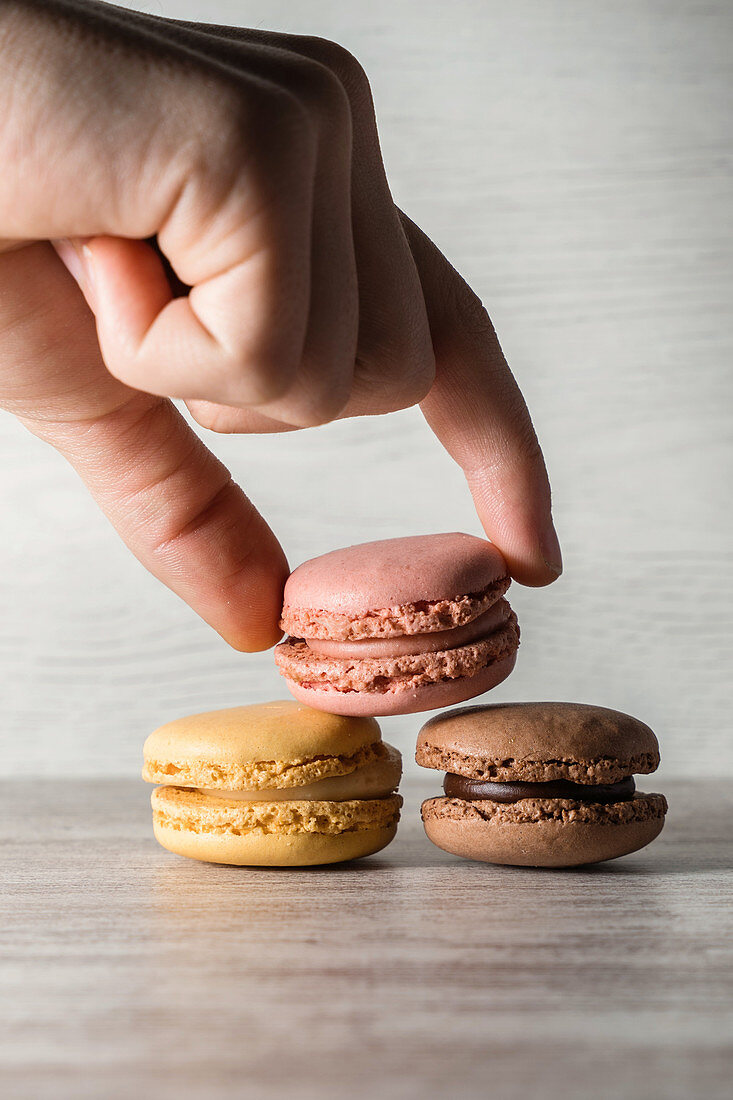 Crop hand placing macaroons on the table