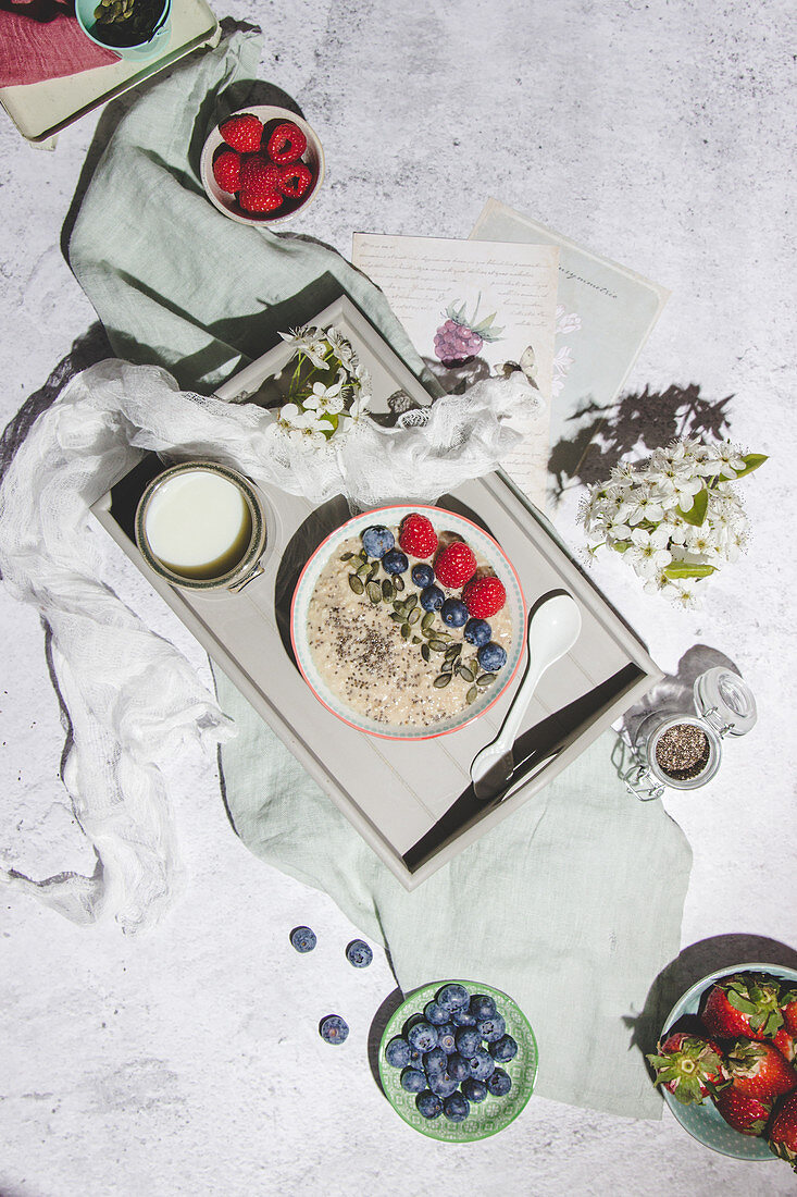 Healthy oat porridge with fresh berries served with cup of milk