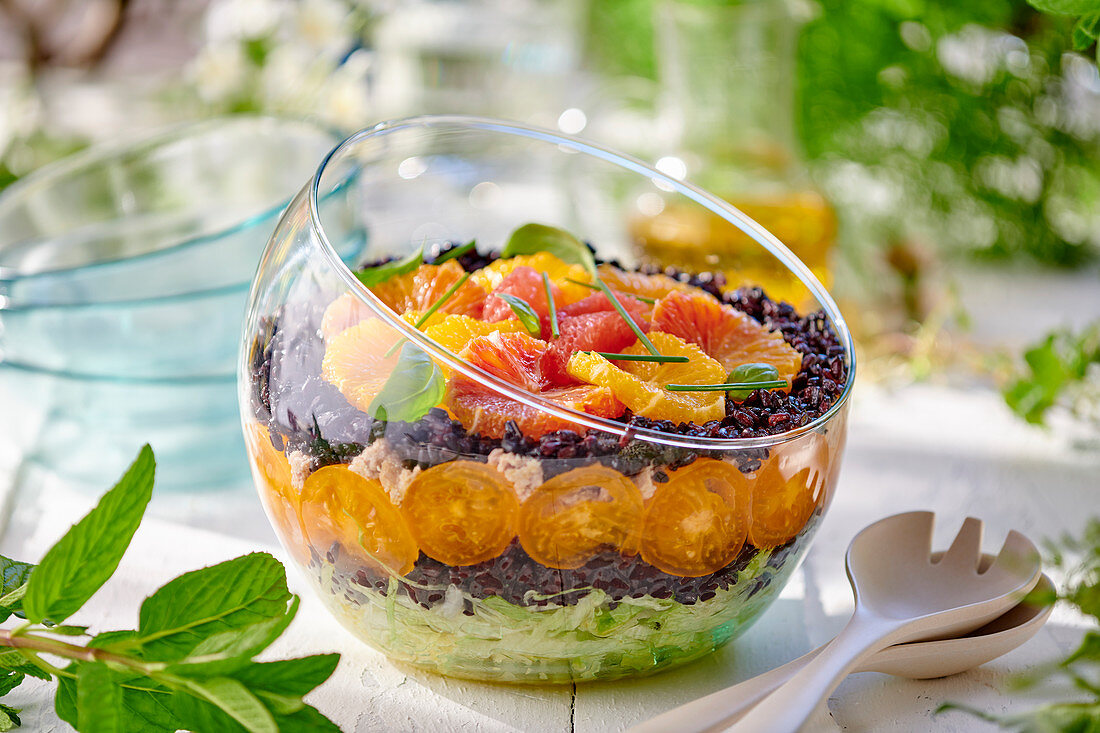 Layered black rice salad with vegetables and oranges