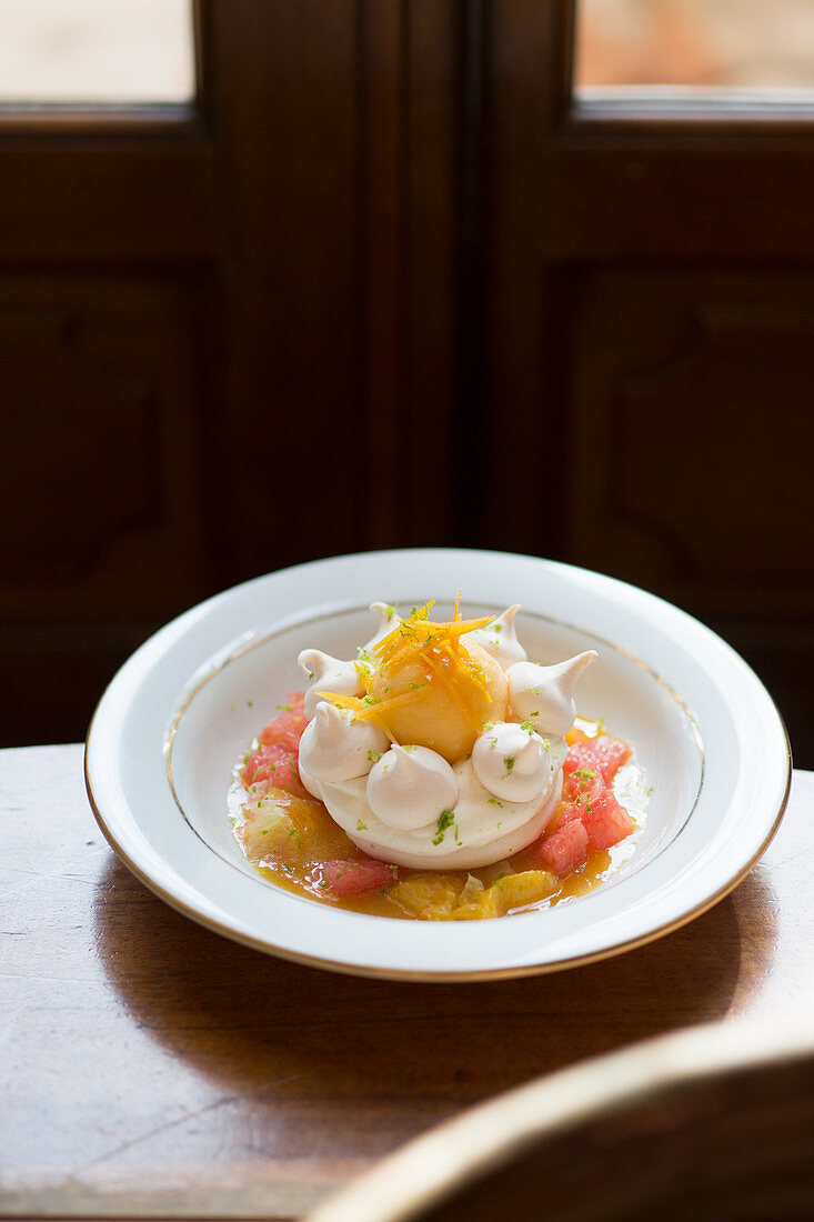 Meringue nest with egg yolk and citrus fruit