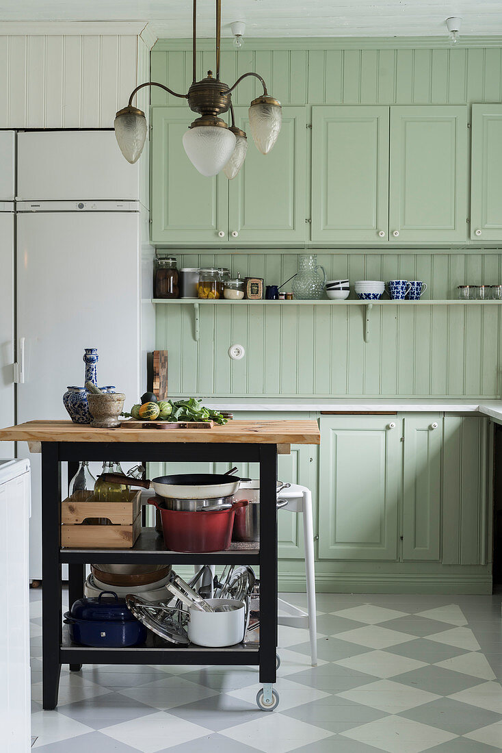 Serving trolley in mint-green country-house kitchen with chequered floor