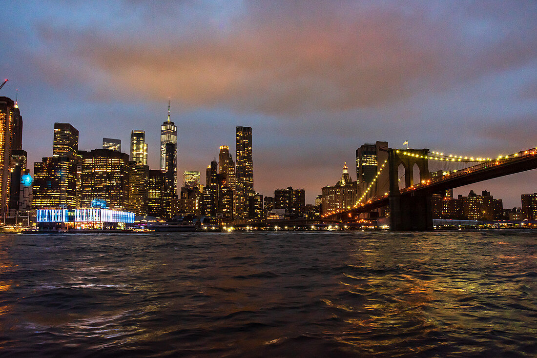 A view of the Brooklyn Bridge and Manhattan lit up in the evening, New York City, USA