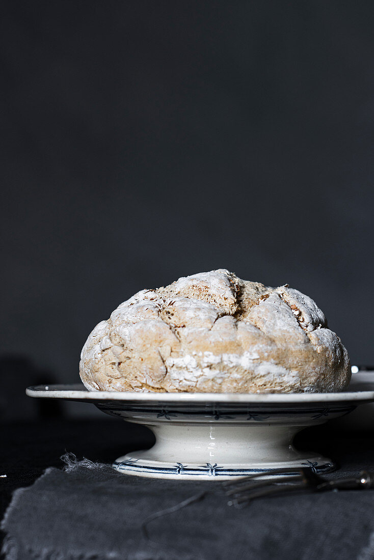 Homemade bread on a pastry stand against a gray background