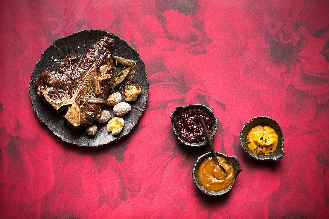 Sweet mustard sauce, spicy carrot and apricot sauce, and vegetables BBQ sauce with a T-bone steak