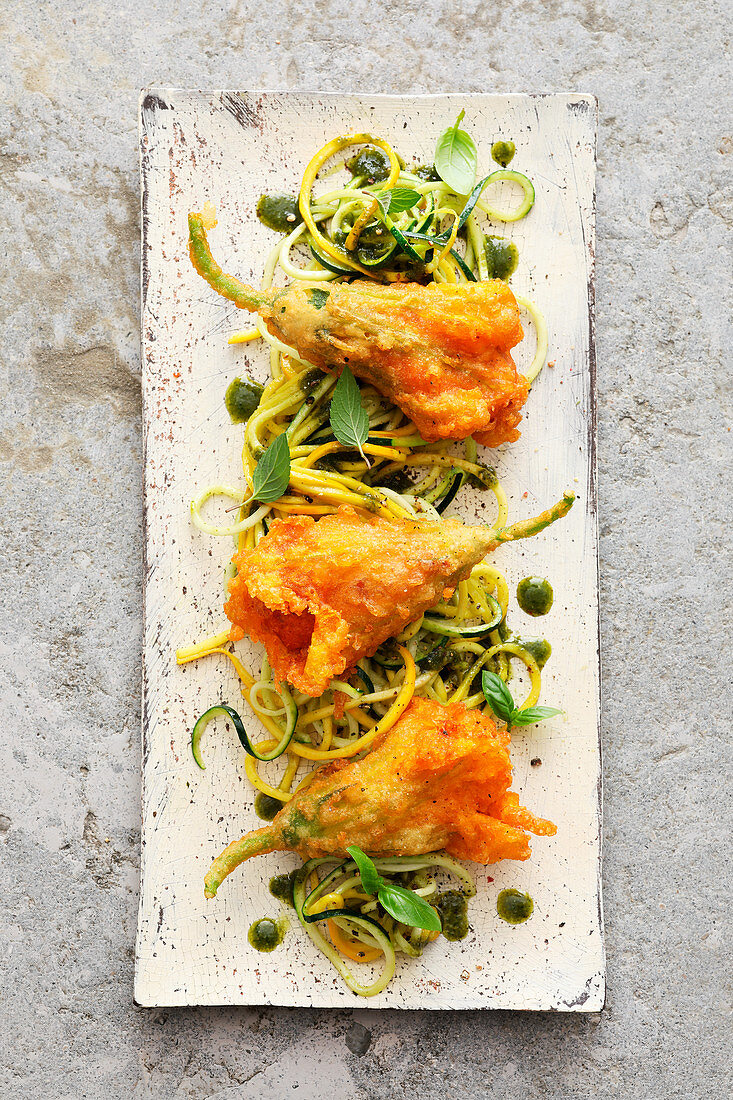 Baked courgette flowers filled with tomato polenta on zoodles