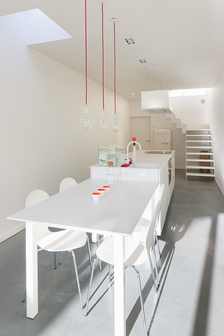 Minimalist dining room with white table and pendant lights