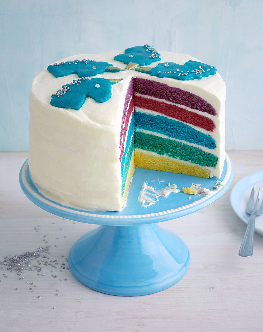 A rainbow cake decorated with a unicorn