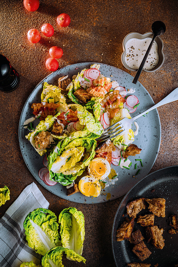 Caesar salad with soft eggs and radishes