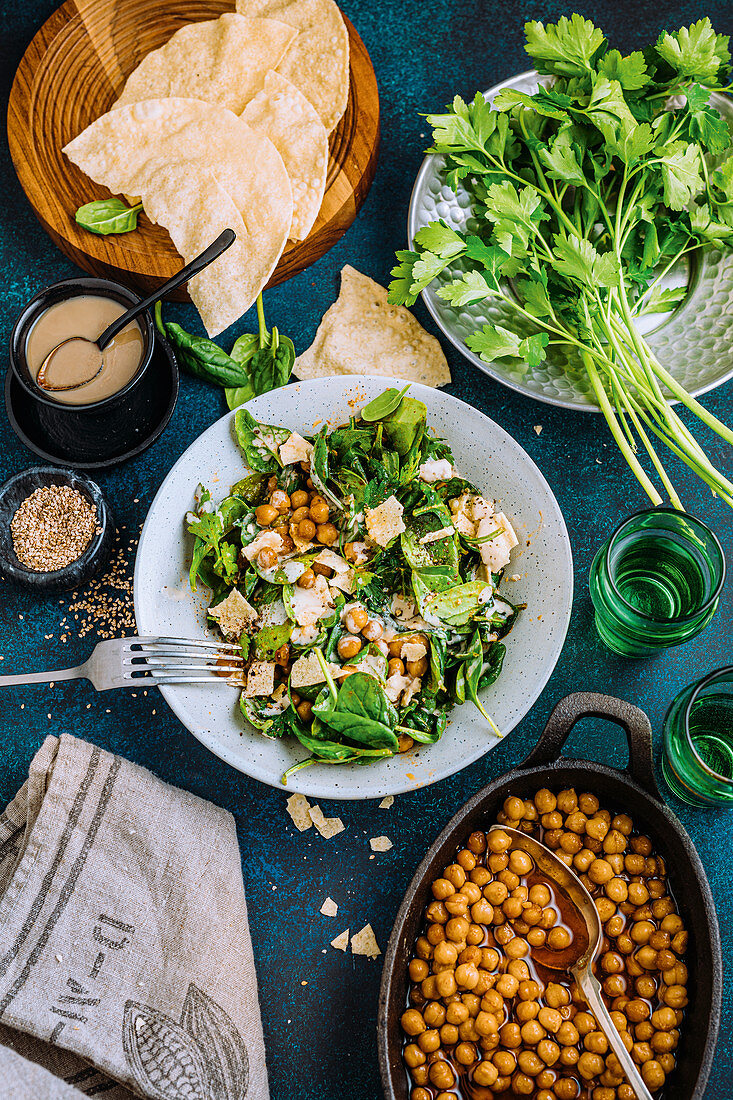 Vegan chickpea and spinach salad with tahini and papadams