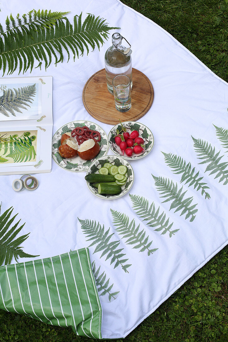 Snacks auf DIY-Picknickdecke mit Farnmotiv