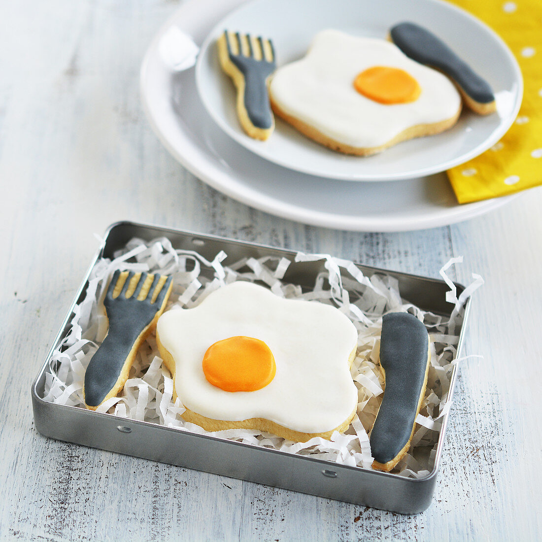 Fried egg and cutlery biscuits in a tin and on a plate