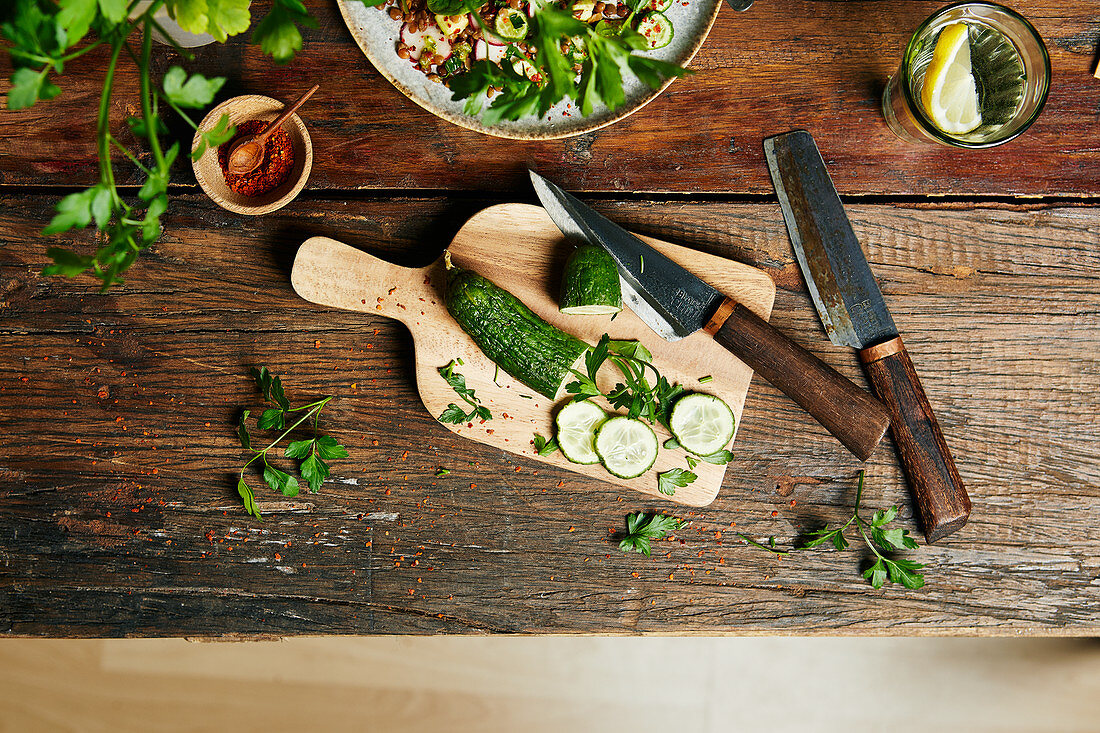 Sliced cucumber on a wooden board with a knife