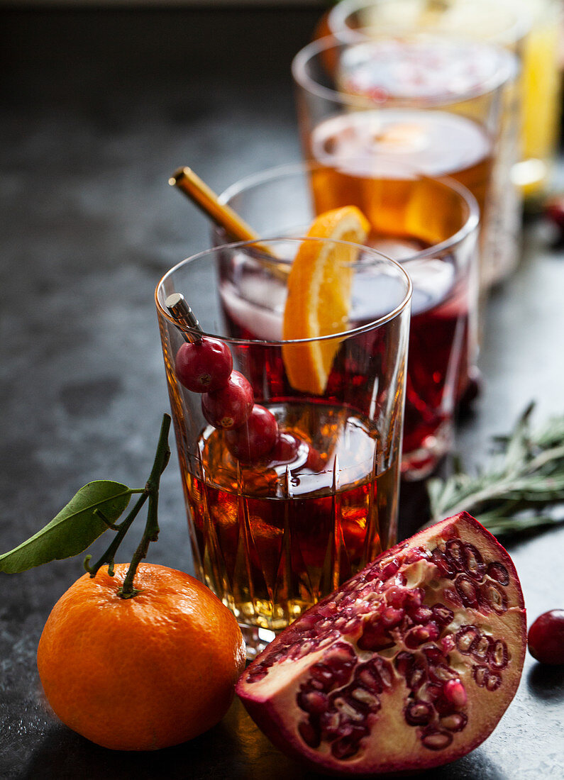 Various alcoholic drinks with whisky, bourbon, vodka, cranberry, oranges, pomegranates, rosemary and thyme