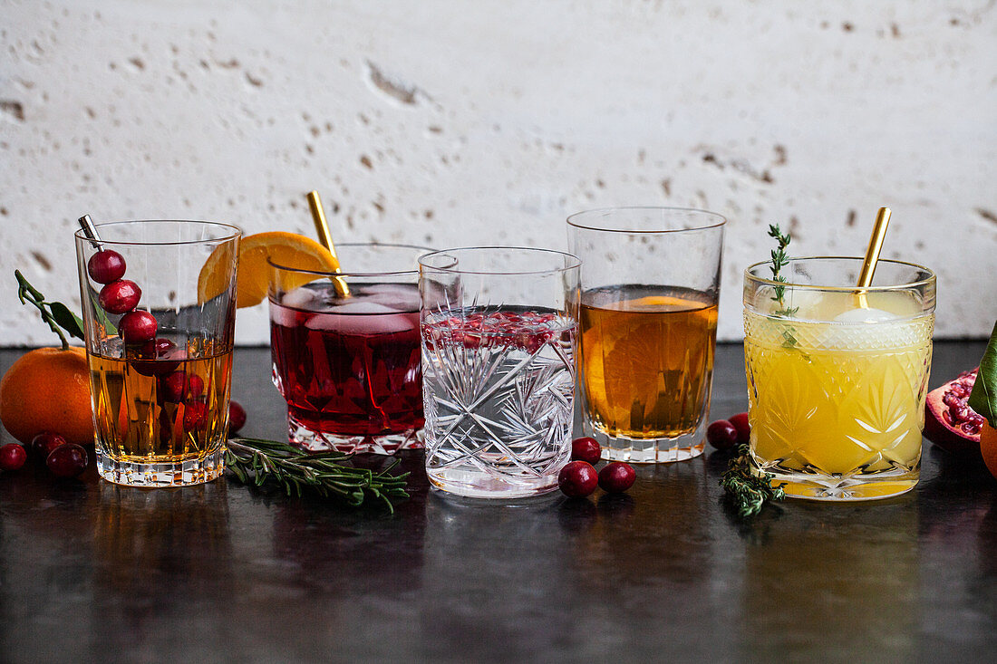 Various alcoholic drinks with whisky, bourbon, vodka, cranberry, oranges, pomegranates, rosemary and thyme