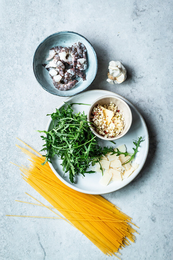 Ingredients for spaghetti with shrimp, arugula and garlic butter