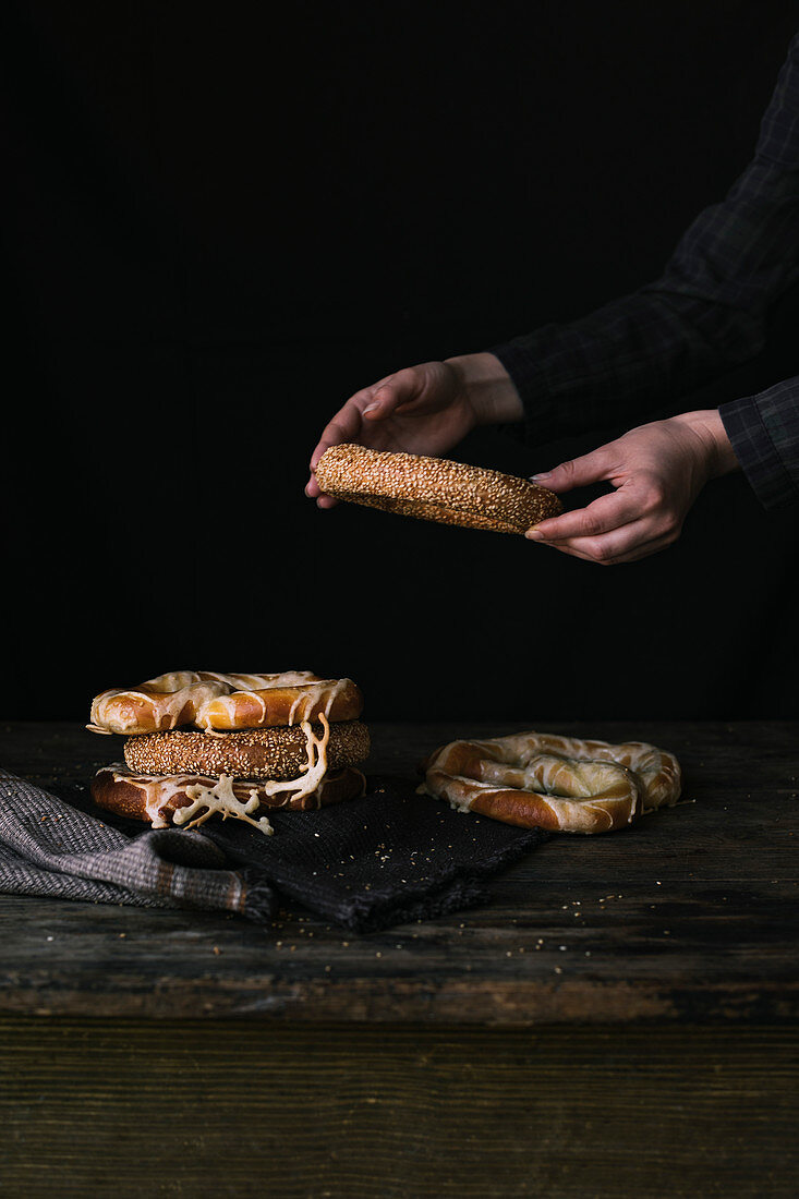 A Women s Hands Taking Bagel on a Black Background