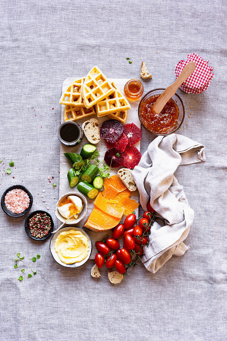 Sweet and Savory Breakfast Board with baguette, blood orange, butter, cheese, coffee, cucumber, gouda, honey, jam, waffles