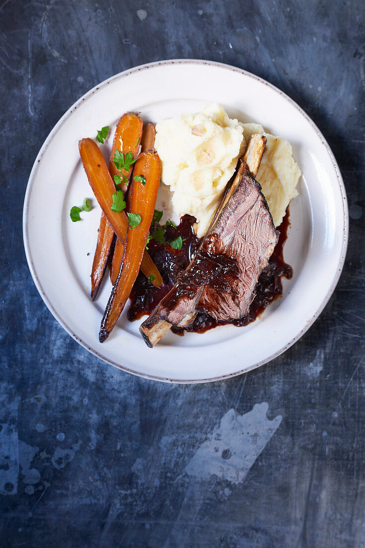 Twice cooked beef short ribs with dripping carrots and gravy and smoked mash