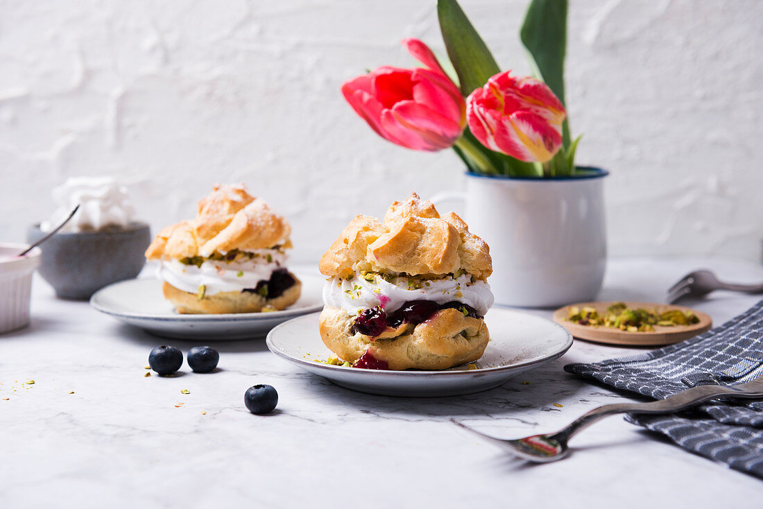 Cream puffs with soy whipped cream, blueberry compote and pistachios