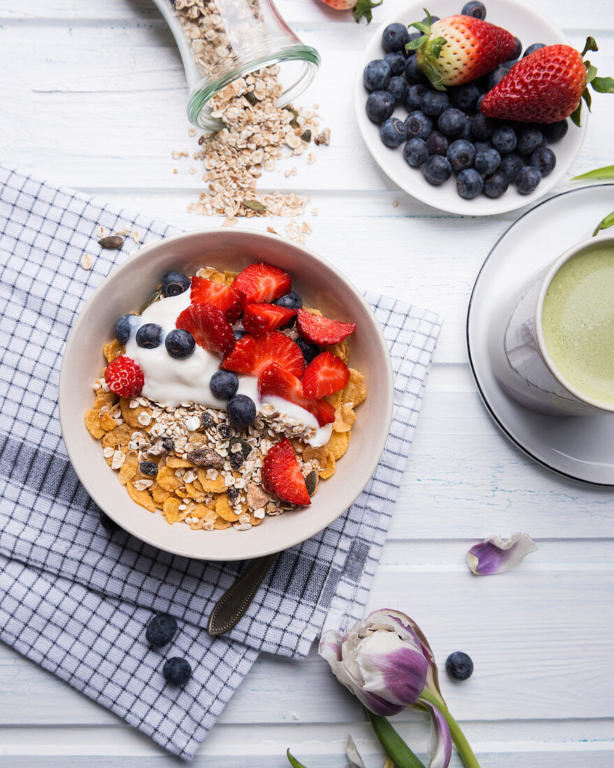 Müsli mit Mandeljoghurt und frischen Beeren, dazu Matchatee