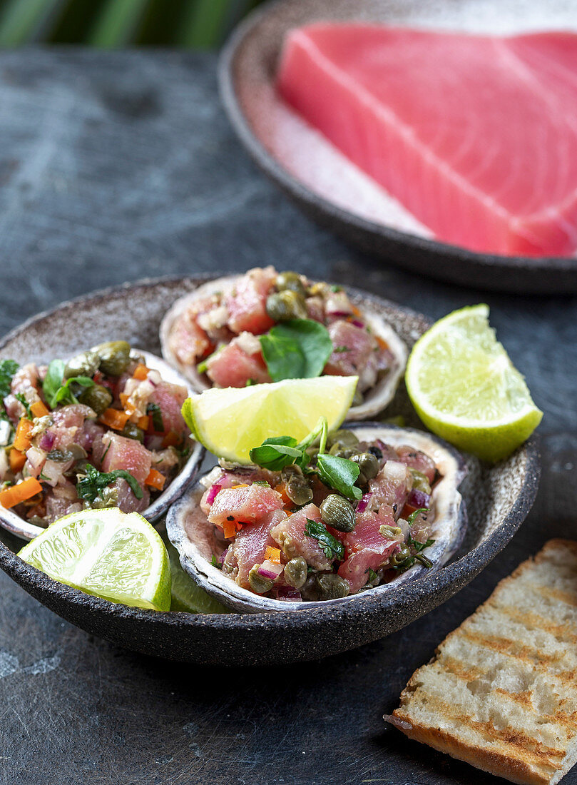 Raw tuna tartare served in seafood shells with lemon