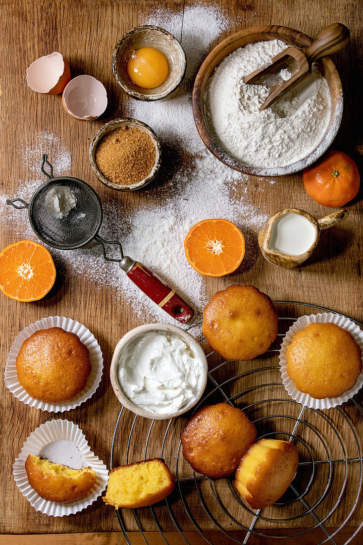 Homemade citrus oranges or clementines sweet muffins cakes with flour and ingredients