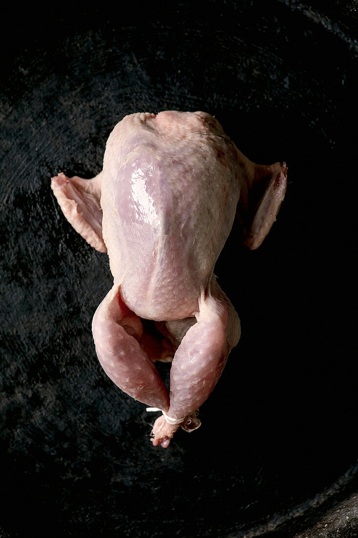 Raw uncooked quail ready for marinat in clay tray