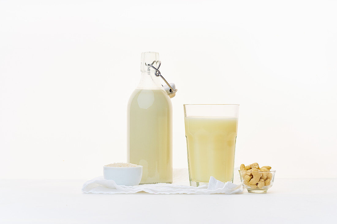 Reismilch und Cashewmilch in Bügelflasche und Glas