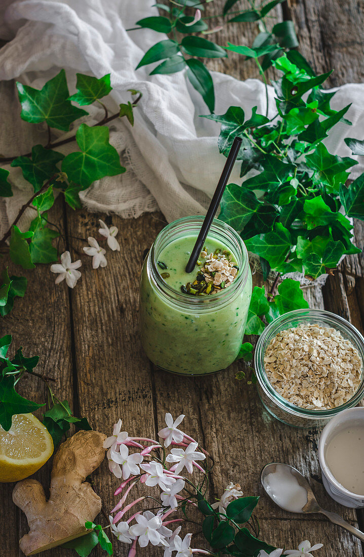 Grüner Smoothie zwischen Smoothiezutaten und Efeublättern