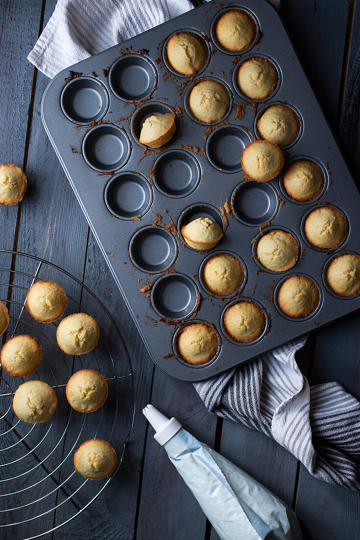 Minimuffins in Backform auf grauem Holztisch