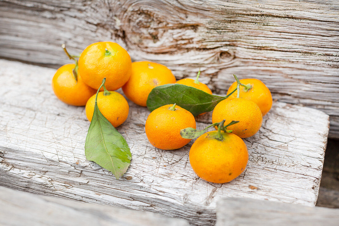Freshly picked tangerines on a wooden background