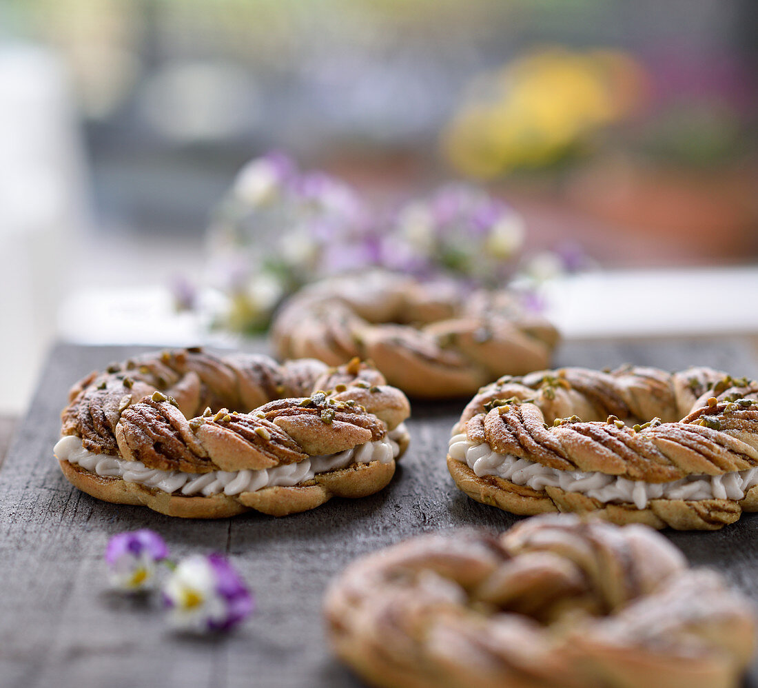 Vegan pistachio yeast dough wreaths filled with coconut and cream cheese frosting