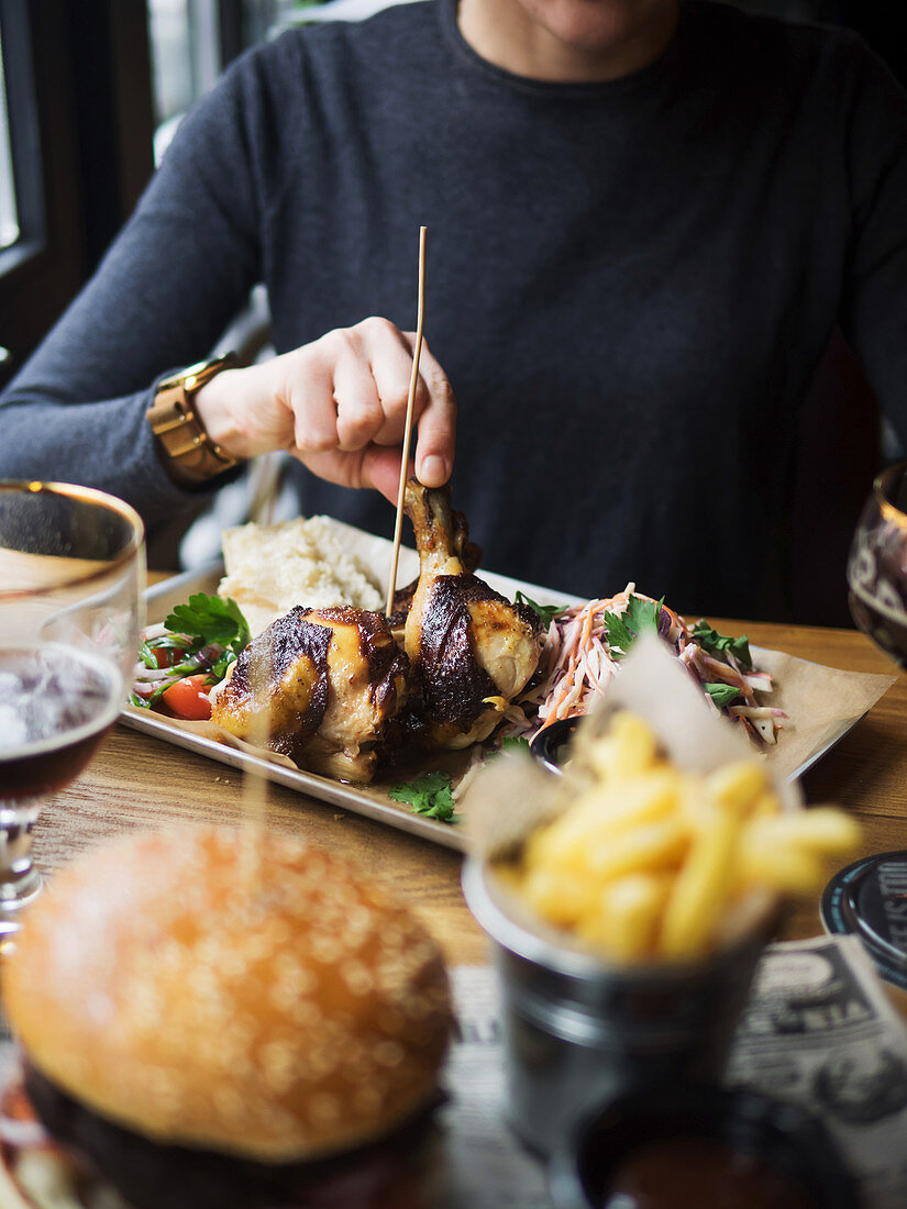 Frau isst gegrillte Hähnchenschenkel