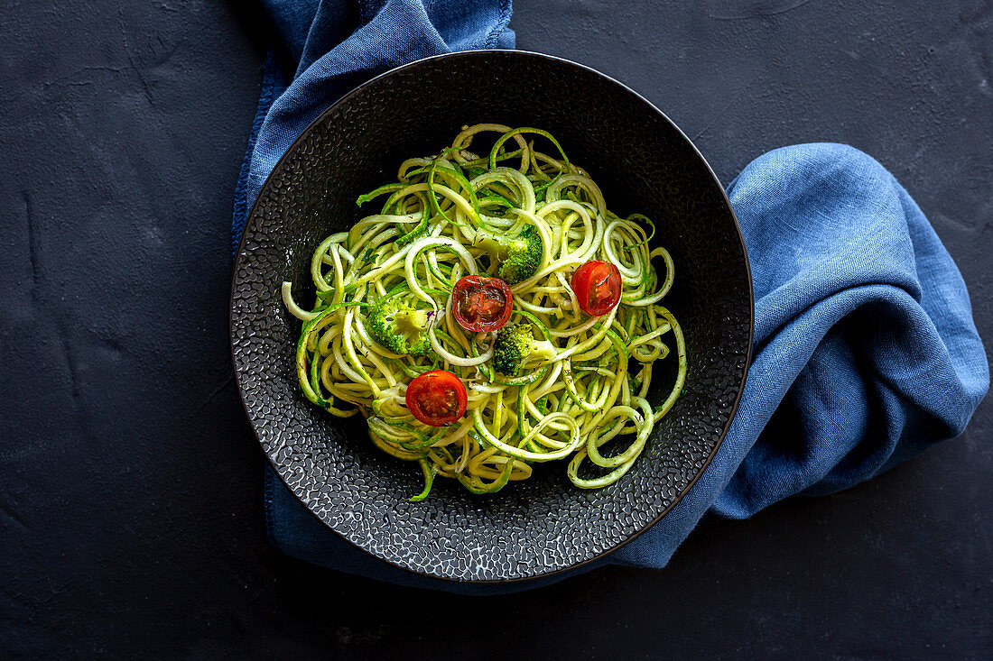 Homemade Zucchini Spaghetti with pesto sauce, broccoli and cherry tomatoes